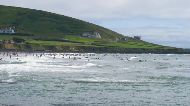 Tourists at Croyde surfing in sea on British coastline, north Devon coast