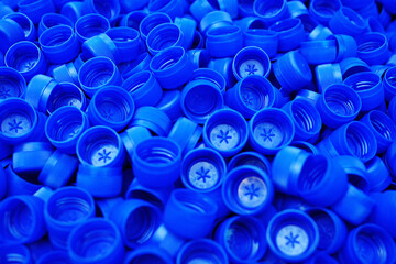 lots of plastic blue pet bottle caps close up.