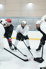 Obraz premium Group of professional hockey players in skates standing in circle on ice rink