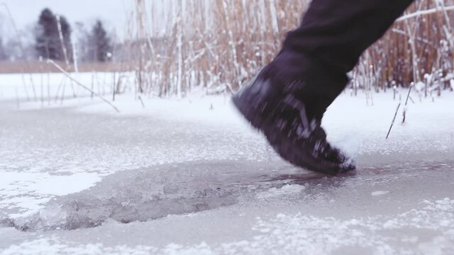 Person who walks on weak ice and steps through the ice and steps into the water on the Swedish Baltic Sea
