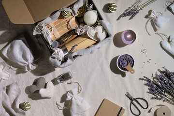 Dry lavender flowers. Hand made lavender sachets in textile bags and soft hearts. Hand hold raft cardboard parcel with zero waste gifts. Bamboo coffee cup, brushes. Low impact lifestyle gift package.