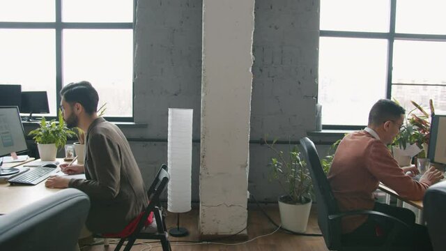 Zoom-out of open space office room and people employees multi-ethnci group working with computers at desks. Business and workplace concept.