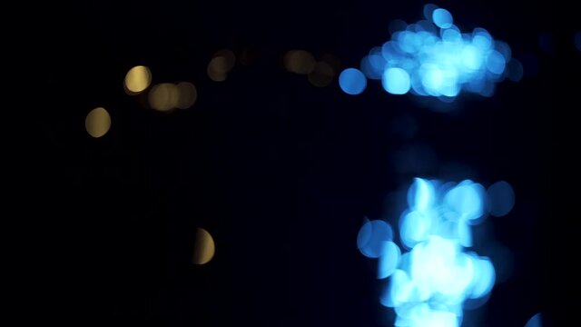Defocused reflection of cold and warm colored lights on the surface of water.