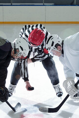 Hockey referee with puck and rivals with sticks standing on his right and left