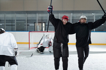 Obraz premium Excited hockey players in sports uniform expressing joy after successful play