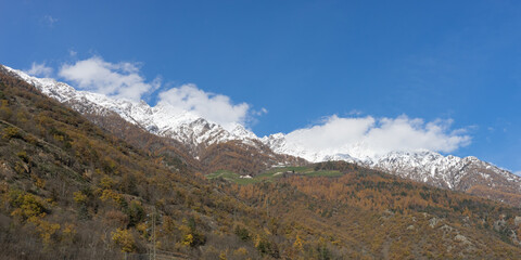 Picturesque mountain landscape in Naturns in South Tyrol in autumn, in the background the snow-covered mountains, blue sky with clouds, no people