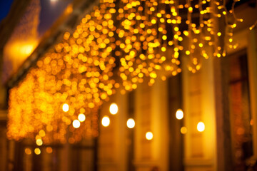Golden lights night city illumination on the building, blurred bokeh effect background.