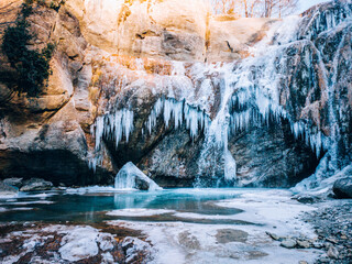 Waterfall in a cave in a cold environment, beautiful frozen landscape. Frozen water. Winter tourism...