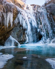 Frozen waterfall in a cave in a cold landscape. Ice formation with cold and frost water. Tourism in Spain, Catalonia, Barcelona, Osona, Vidra, Salt del Moli.