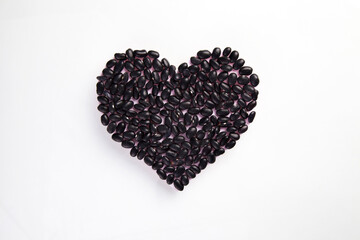 heart made of raw black beans on white background, healthy life and nutrition concept