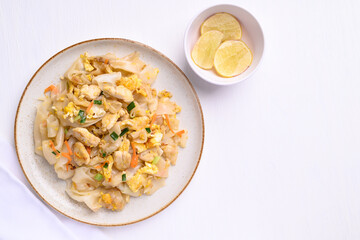 Thai food (Kuaitiao Khua Kai), Stir fried rice noodles with egg and chicken on white background, Top view