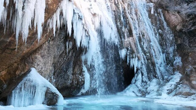 Waterfall in a cave in a cold environment, beautiful frozen landscape. Frozen water. Winter tourism in Spain, Catalonia, Barcelona, Osona, Vidra, Salt del Moli. 4k stock nature video.
