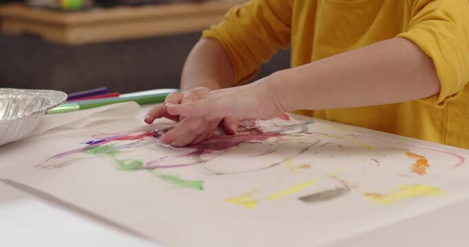Cute little toddler girl painting. Cinematic 4K footage.