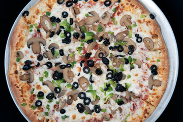 Overhead view of veggie vegetable covered pizza with melted cheese tempting for those avoiding meat.