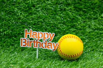Naklejka premium Softball birthday with ball and sign on green grass