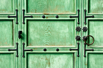 Old wood doors painted green and with black metal decoration, Jogyesa Buddhist temple, Seoul, South Korea