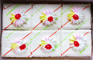 Delicious cake in box packaging. Close up of whipping cream cake decoration.