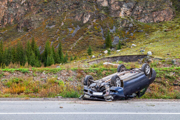 Car accident place on a bend, overturned car lies on the roof
