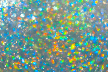 Sparkling rainbow bokeh spots and sequins. Bright blurred background with multicolored glitter
