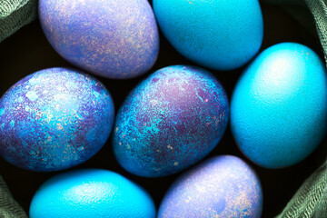 Painted Easter eggs in blue, green and purple close-up.