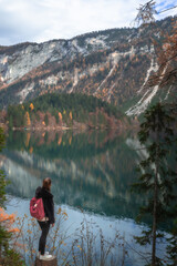 Girl in front of a lake with mountains in autumn and yellow trees