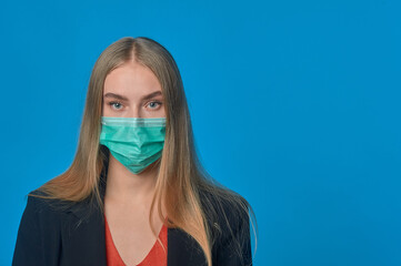 A woman in a medical mask on a blue background