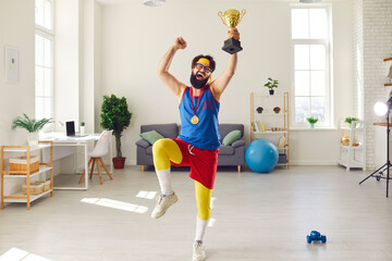 Funny, happy, crazy young athlete in glasses, retro sportswear and with gold medal on chest jumping...