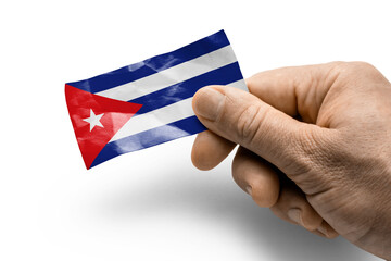 Hand holding a card with a national flag the Cuba