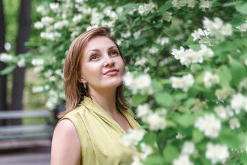 cute caucasian 30th woman in blooming garden