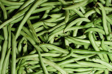 piles of green beans that are on the market and are freshly harvested. This vegetable is commonly used for food side dishes. Beans can be used as an abstract background. Mockup and design vegetables.