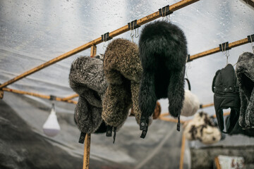 natural fur winter hats skins of killed animals at the craft market.