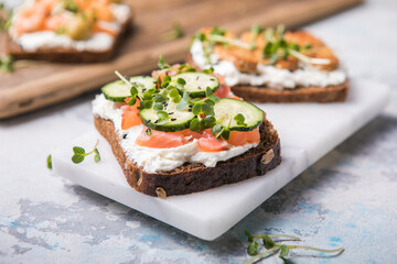 Salmon toast with a micro-green on  wooden background,  concept of healthy eating,  assortment of bruschetta