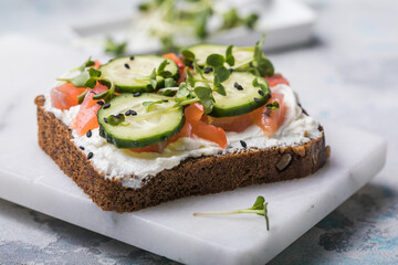 Salmon toast with a micro-green on  wooden background,  concept of healthy eating,  assortment of bruschetta