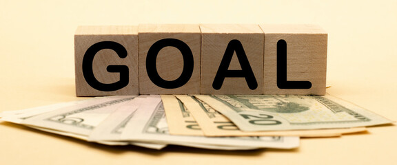 the word goal on wooden cubes and American dollars