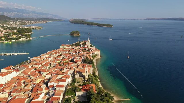 Aerial drone footage of the Rab old town on Rab island along the Dalmatia coast in Croatia in the Balkans. Shot with a forward tilt down motion. 