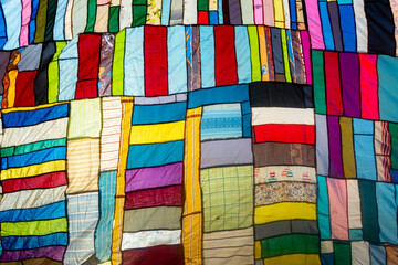 A huge colorful artistic fabric, made from a combination of colorful pieces of unused and collected...