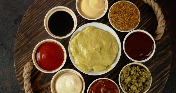 Different types of sauces on plates on tray rotate. 