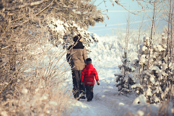 The man and the boy in winter forest. Father and son