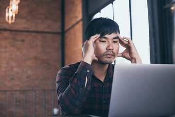 sad depression serious people from work,study stress concept.asian man feeling tired suffering using computer working work place.concept global economic,health problems