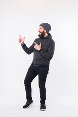 Fototapeta premium Photo of a whole mans body looking and pointing away is smiling standing near a white wall .
