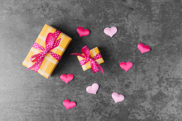 Big and small yellow gift boxes on grey stone background. Valentine’s day concept