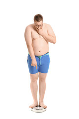 Stressed overweight man with scales on white background. Weight loss concept