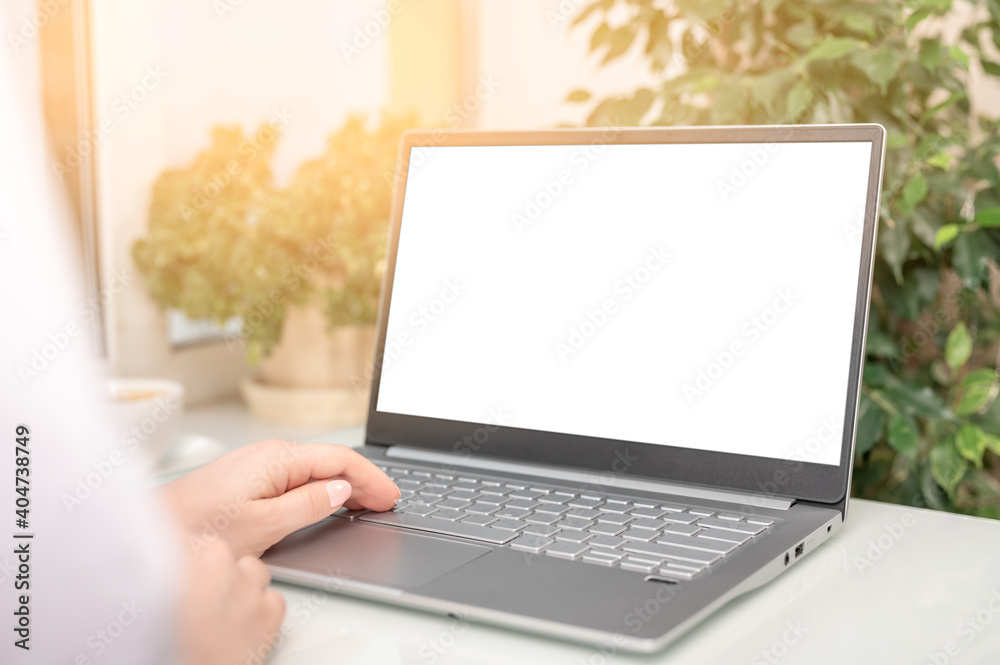 Poster hand typing laptop computer showing blank white screen on table office place. blank screen laptop co