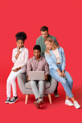 Obraz premium Surprised teenagers with modern laptop on color background
