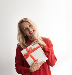 Young woman holds white gift box and thinking what inside. Person very pensive face look away. Girl...