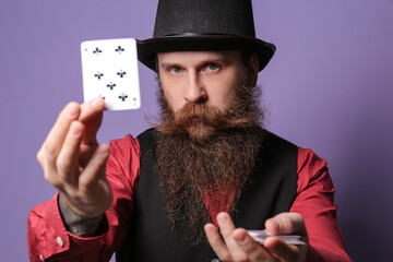 Male magician with cards on color background