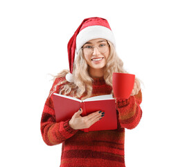 Beautiful young woman in Santa hat with book and cup on white background