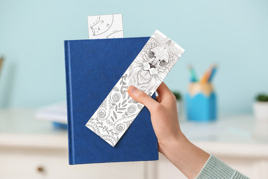 Woman with cute bookmarks and book at home