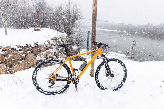 Orange Mountain Bike In Snowy Landscape