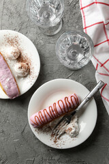 Concept of sweet meal with delicious eclairs on gray background